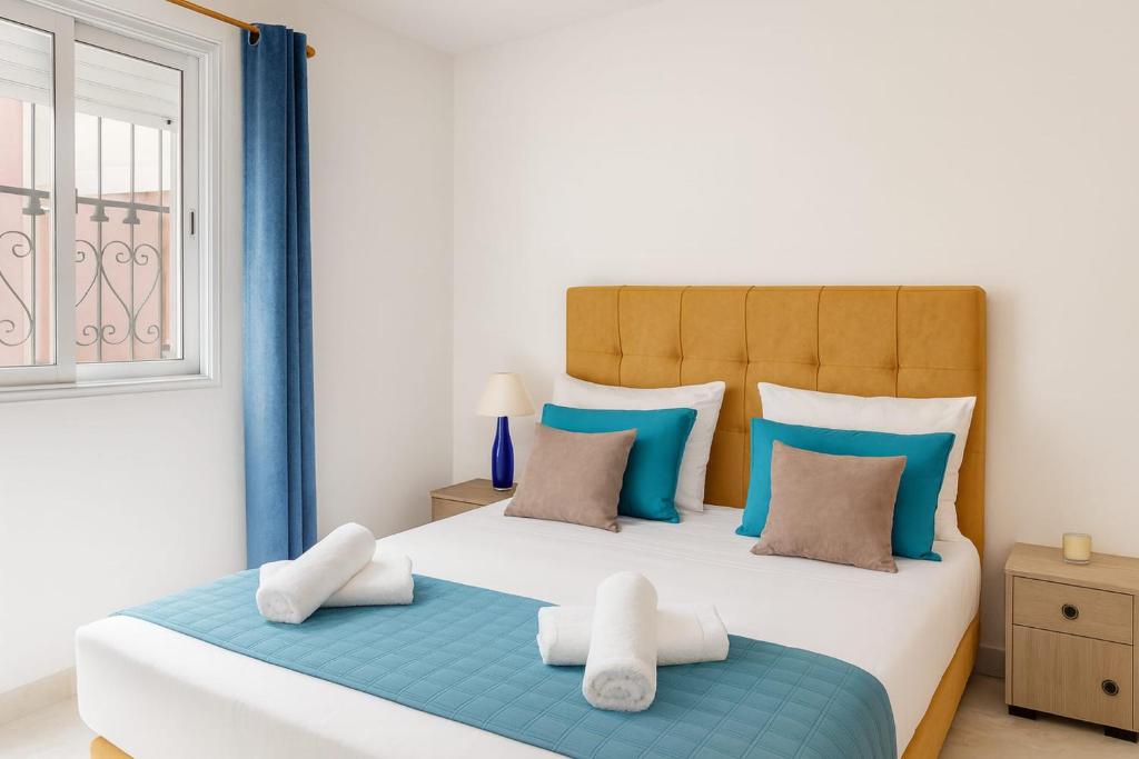 Un dormitorio con una cama grande con almohadas azules y blancas. en Elegant Villa with Private Pool in South Hammamet 2P, en Hammamet Sud