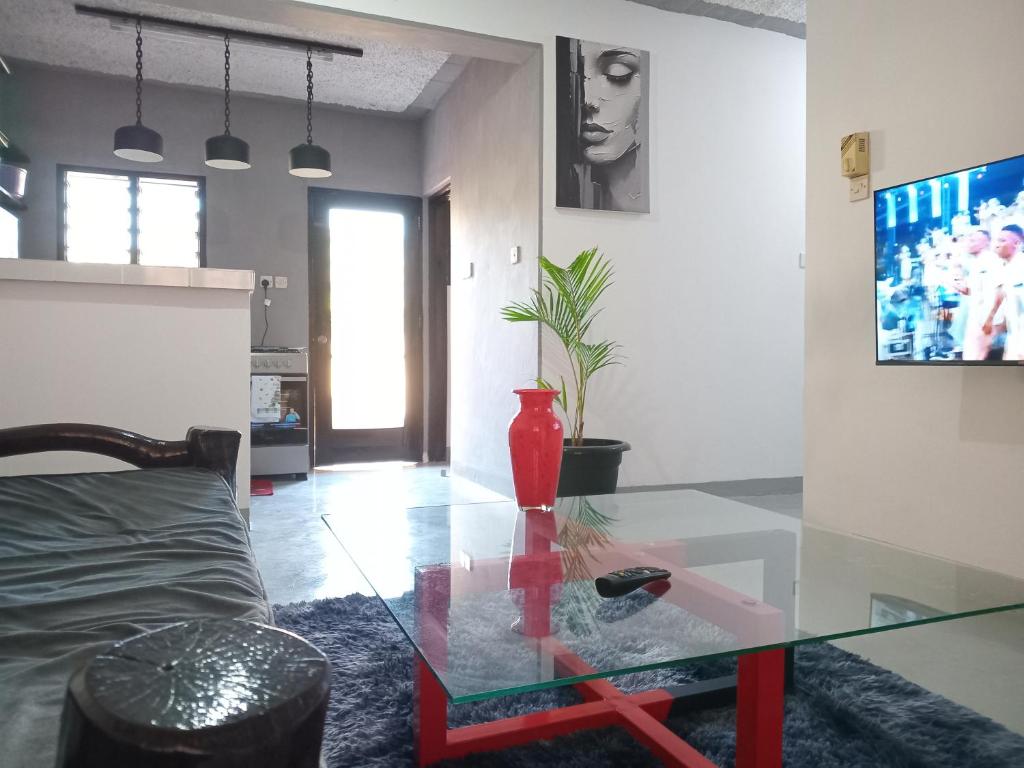 a living room with a glass table with a vase on it at TN apartments voism in Diani Beach