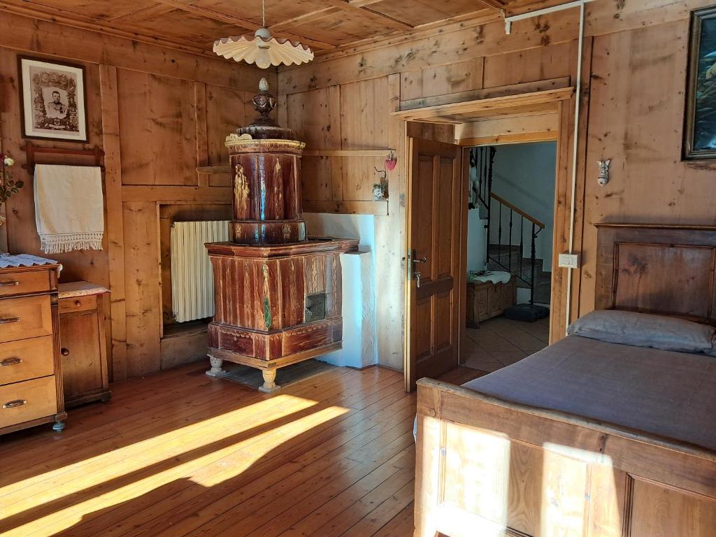 a bedroom with an old woodburning stove in a cabin at Casa della Nonna in Celledizzo