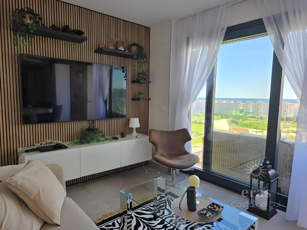 un soggiorno con TV, divano e sedia di Elegant Duplex Penthouse A116 a Las Lagunas Mijas