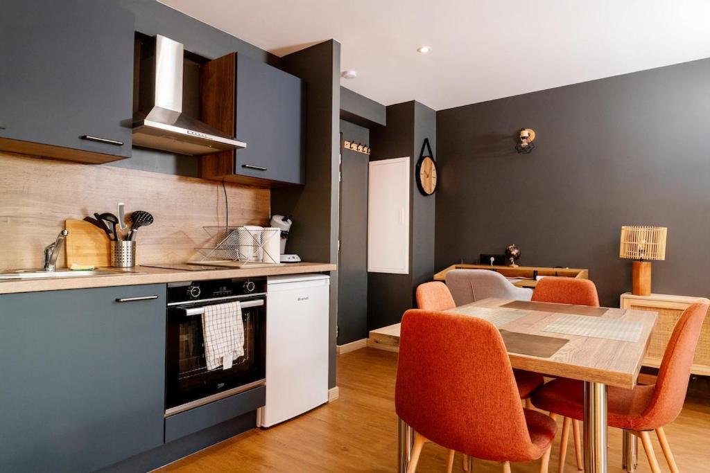 une cuisine et une salle à manger avec une table et des chaises dans l'établissement Studio 104 le Graphite - Modern & Elegant, à Bertrange