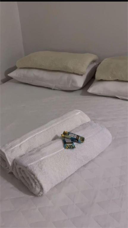 a white towel on a bed with two pillows at Pousada Eucalipto in Água Preta