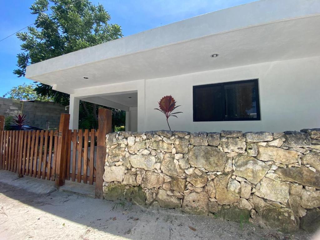 a house with a stone wall and a fence at El Sol del Cuyo in El Cuyo