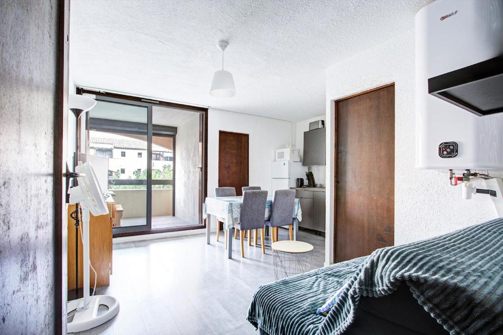 Un dormitorio con una cama y una mesa y sillas. en Studio refait neuf ,4 personnes, terrasse, parking privé, climatisation, en Le Barcarès