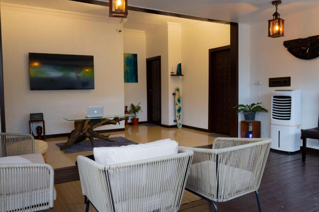 a living room with chairs and a table and a laptop at Samaik Thulusdhoo in Thulusdhoo