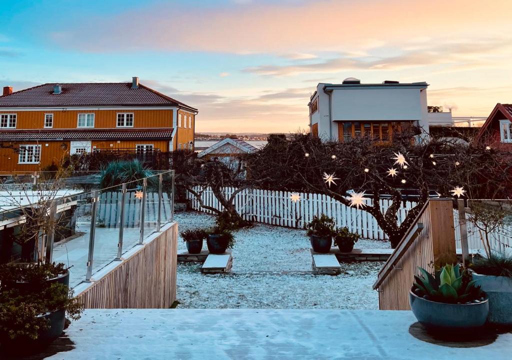 a house with a fence and a yard with plants at Apartment on idyllic Bygdøy with free parking in Oslo