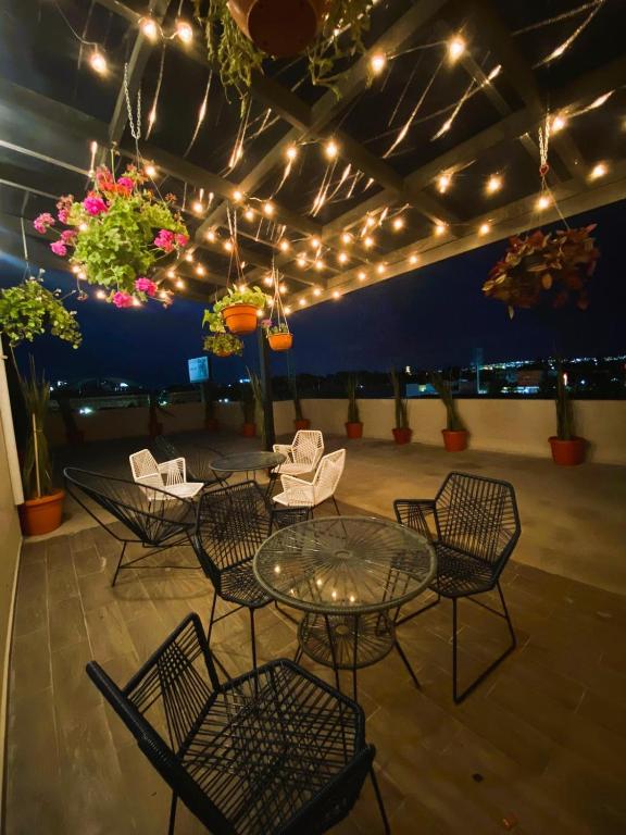 a patio with a table and chairs and lights at Living Alameda in Querétaro