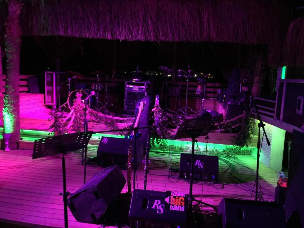 カラブルンにあるFOR You35の紫と緑の照明と椅子のあるステージ