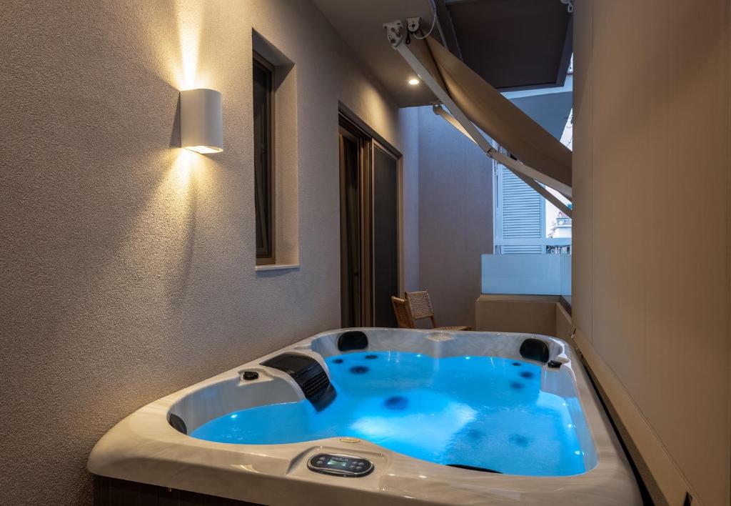 Devina Residence 2025 , Luxury City Jacuzzi Apartment في مدينة خانيا: حمام مع حوض أزرق في الغرفة