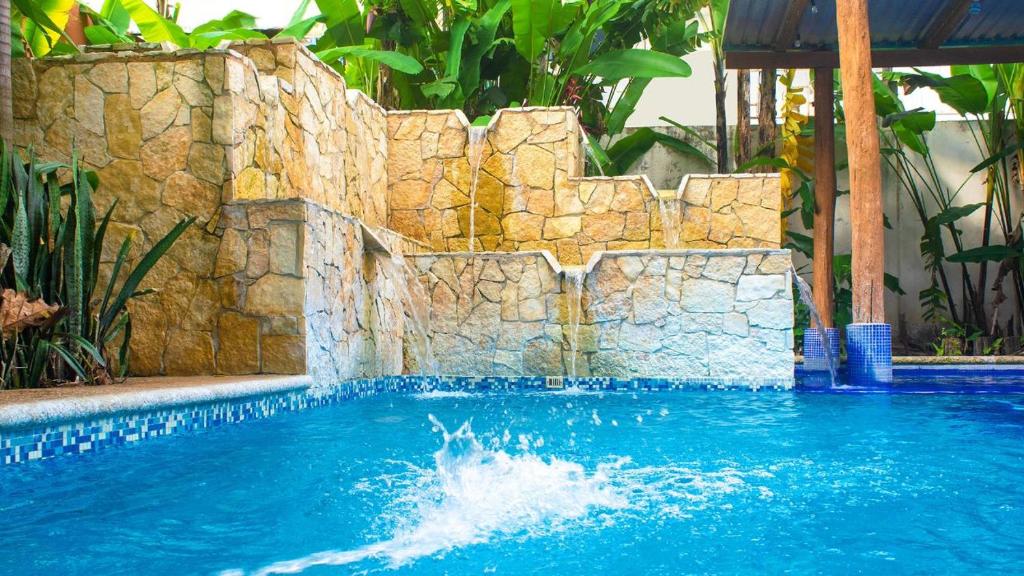 una piscina con una pared de piedra y agua en Hotel Palenque, en Palenque
