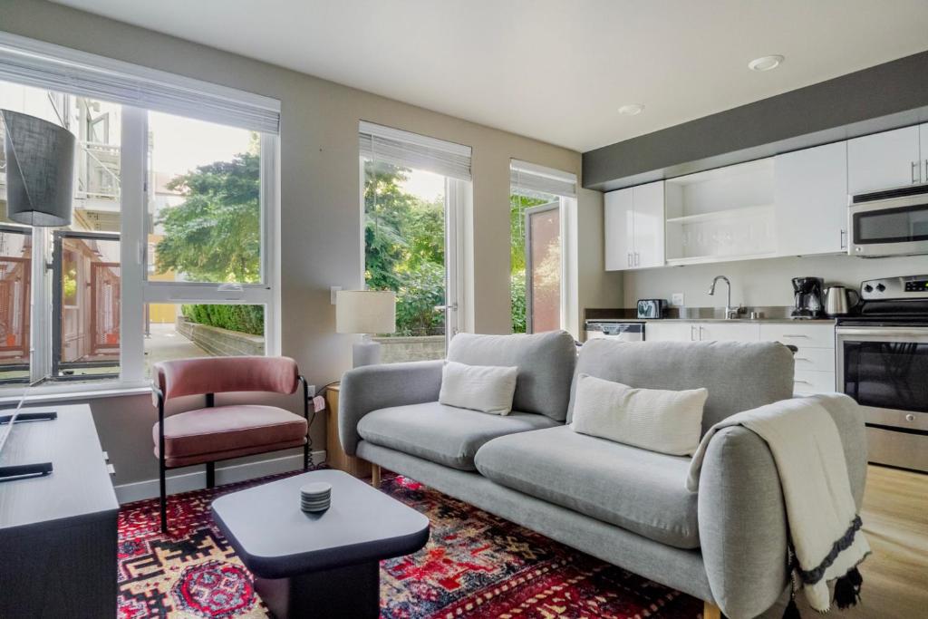 Una sala de estar con un sofá y una cocina. en Blueground Overlake fitness center nr Park SEA-897, en Highlands