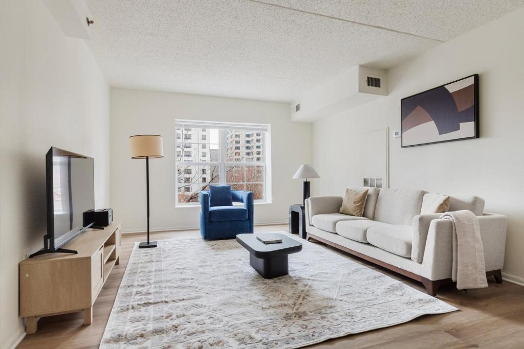 a living room with a couch and a tv at Blueground Hudson Exchange pool nr Liberty Park NYC-2174 in Hoboken