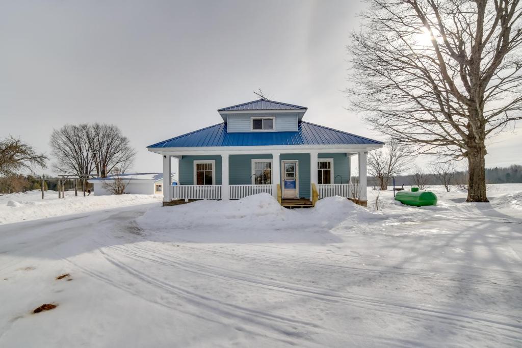 een huis met een blauw dak in de sneeuw bij Secluded and Peaceful Upper Peninsula Getaway! in Chatham