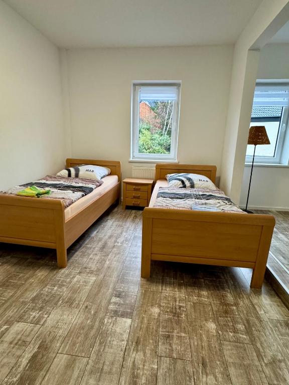 two beds in a room with two windows at Apartment im Grünen in Kroppach