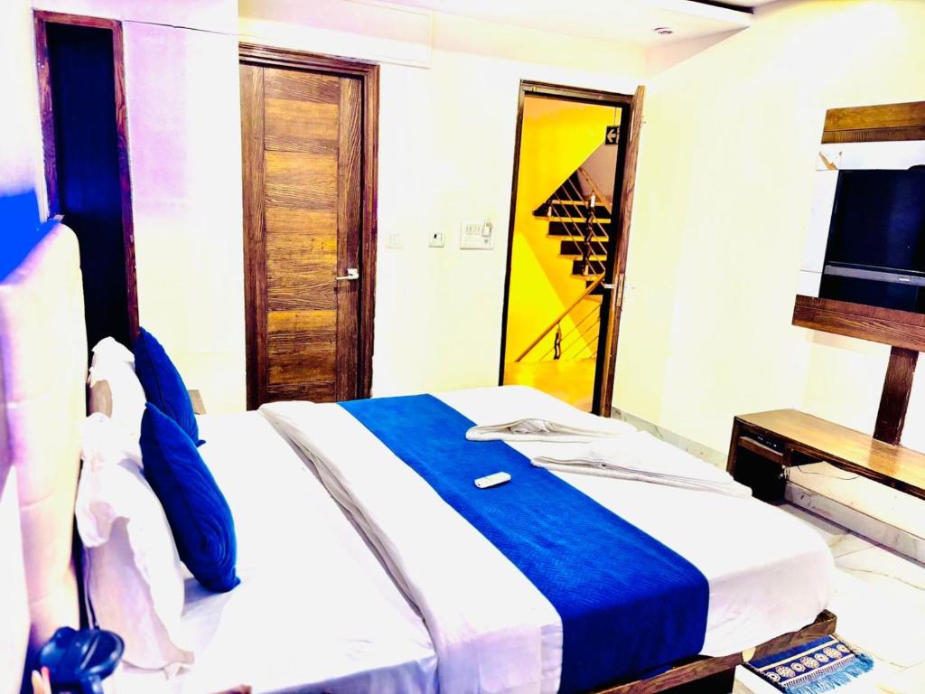 a bedroom with a bed with a blue blanket and a mirror at Hotel Cashev & front of Paharganj Side Railway station in Jāmb