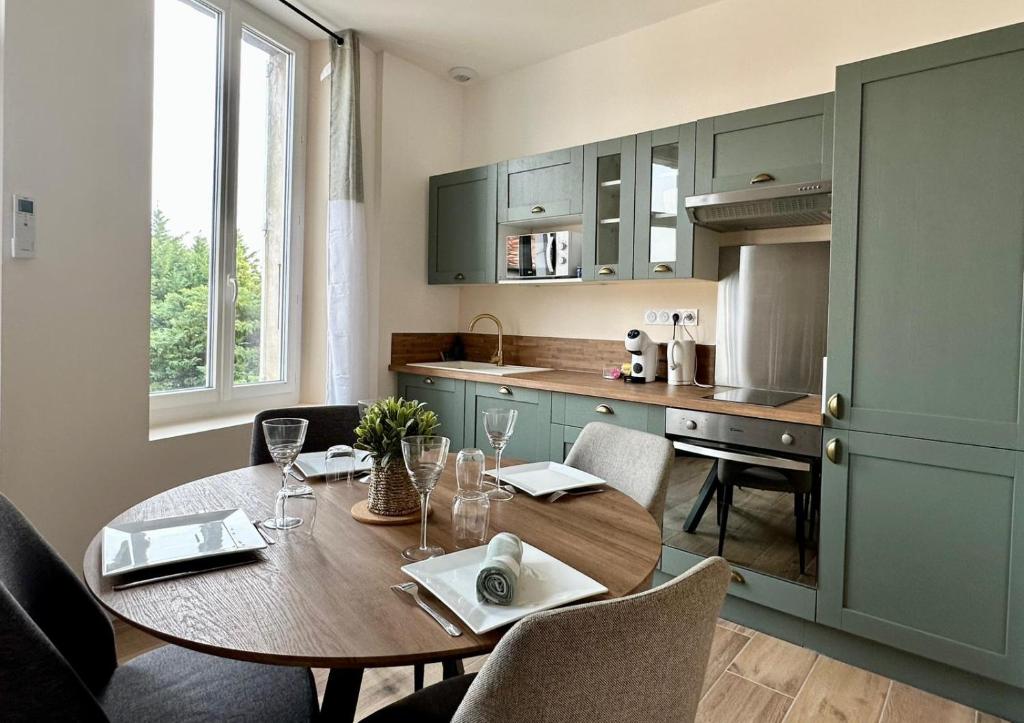 a kitchen with a wooden table with chairs and a dining room at Le 37 FOCH in Orange