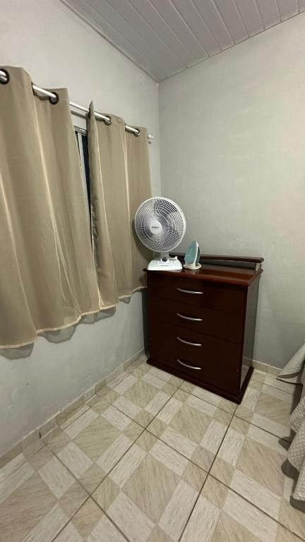 une pièce avec une commode et un ventilateur dans une pièce dans l'établissement Beach Loft, à Vila Velha