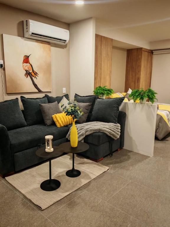 a living room with a black couch and a table at Loft Centro Zapopan in Guadalajara