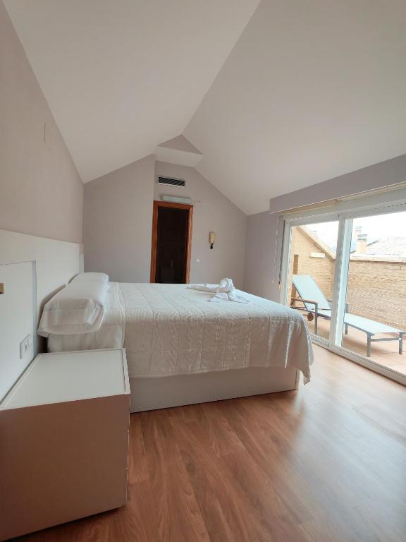 a white bedroom with a large bed and a large window at Beachfront chalet in Valencia in Valencia