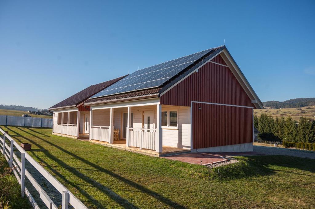 a red and white barn with a fence at Domki u Wojtka in Grywałd