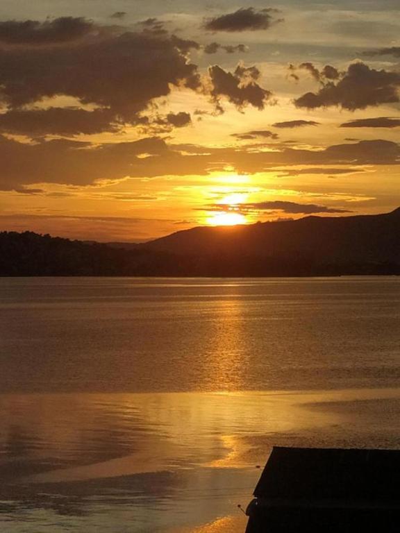 a sunset over a large body of water at Casa Maria Mar in São José