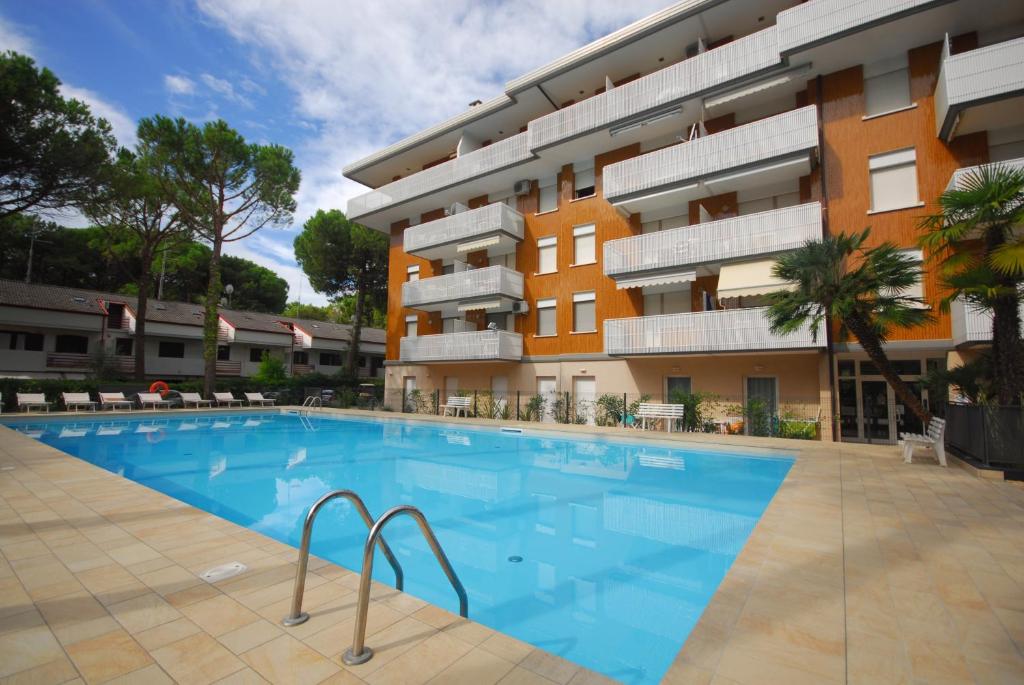 una gran piscina frente a un edificio en Residence Schubert, en Lignano Sabbiadoro
