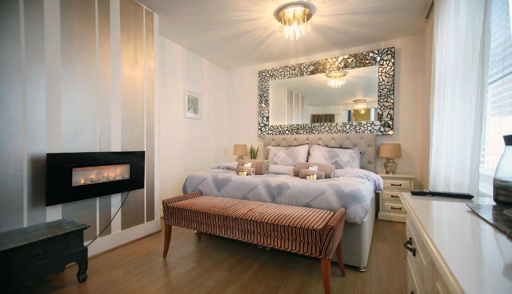 a bedroom with a bed with a fireplace and a mirror at The Wellington Restaurant and Bar in Portsmouth