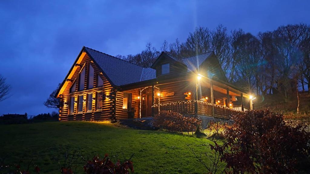 une maison en bois sur une colline la nuit dans l'établissement Eaglewood Lodge, à Carrowkennedy