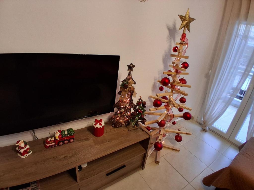 Una sala de estar con árboles de Navidad y un televisor de pantalla plana. en Evi's Apartment, en Perea