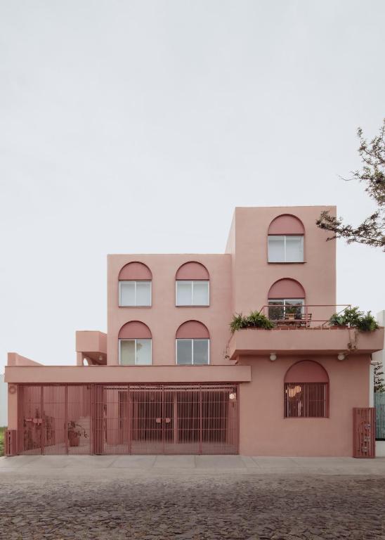 a pink building with a fence in front of it at Casa Rosa in Querétaro