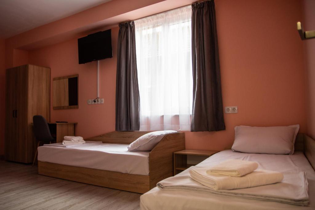 a hotel room with two beds and a window at Dzhorgovata Guesthouse in Govedartsi