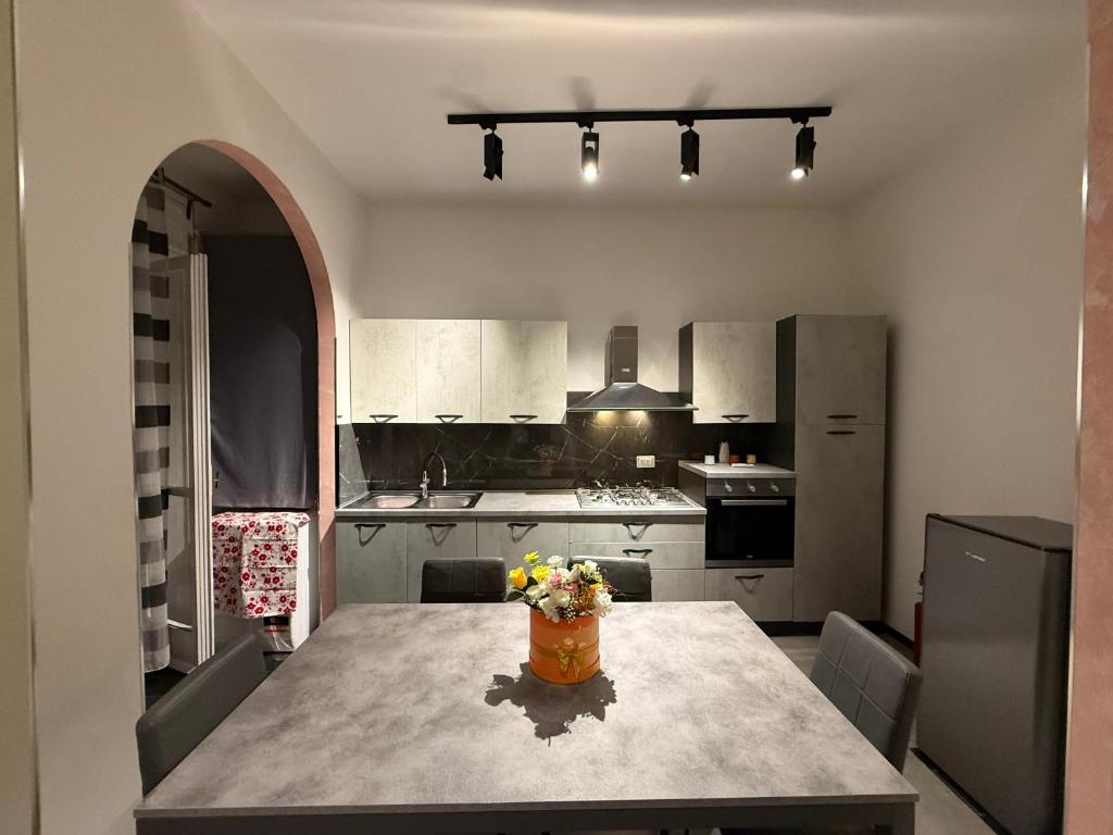 een keuken met een tafel met daarop een vaas met bloemen bij One home in Salerno