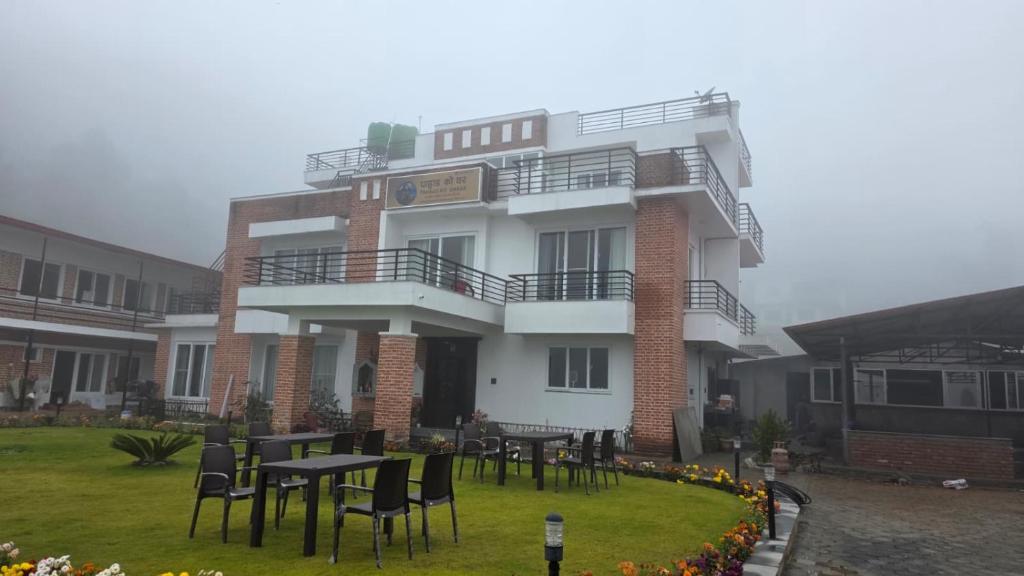 a building with tables and chairs in front of it at Pahaad Ko Ghaar in Nagarkot