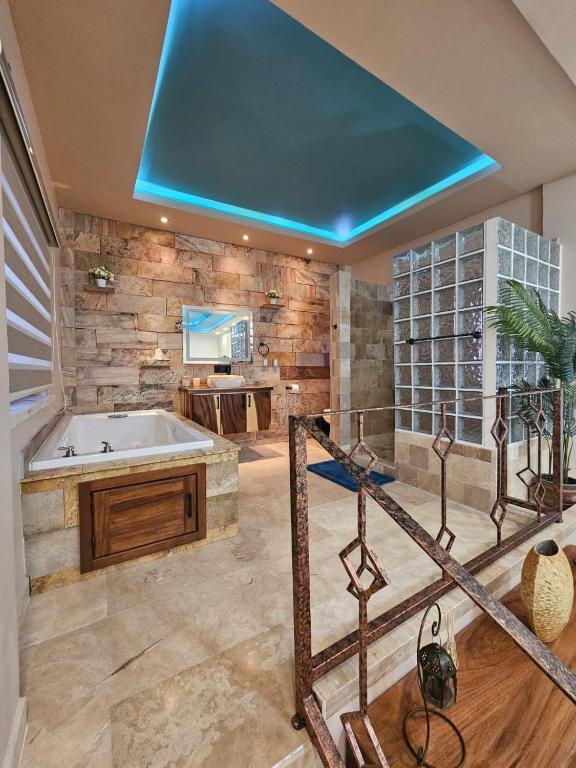 Casa Flor del Desierto في لوريتو: حمام كبير مع حوض استحمام ومغسلة