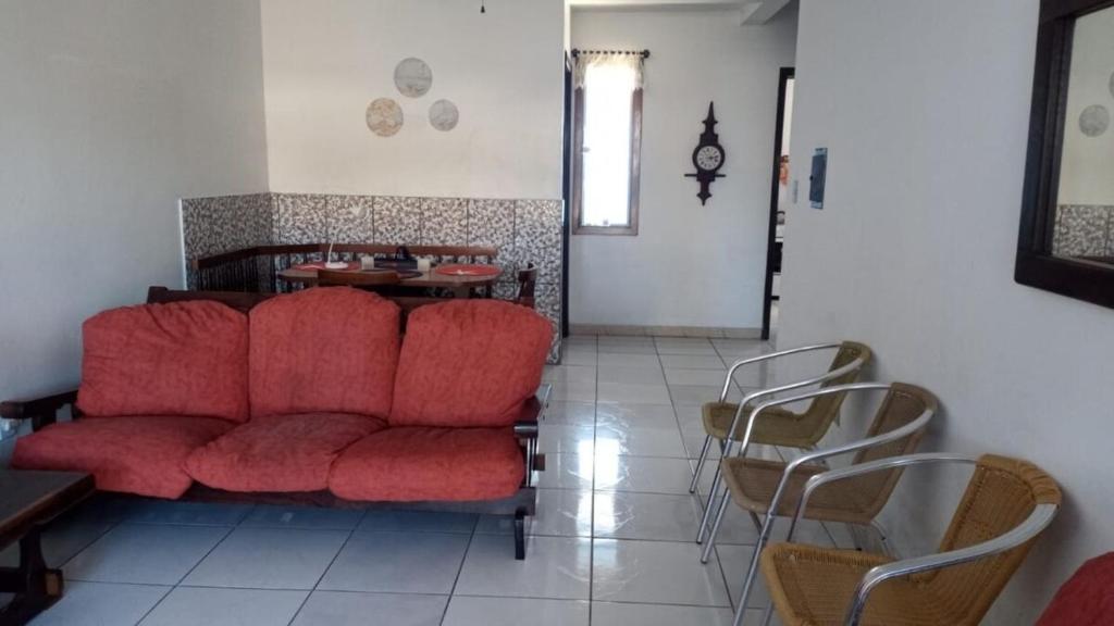 a living room with a red couch and chairs at Casa paulo e nubia in Imbé