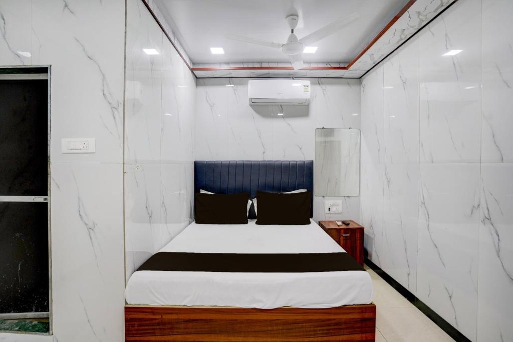a bedroom with a bed in a white wall at Hotel O SR Residency in Mumbai