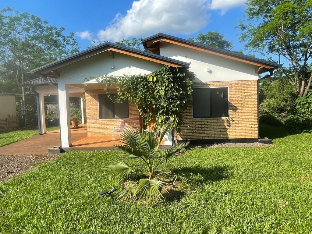 a small brick house with a green yard at Casa Bella Vista 1 Paraguay in Bella Vista