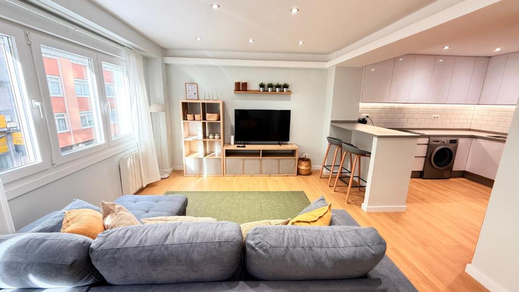 a living room with a couch and a kitchen at Fogar de Breogan in A Coruña