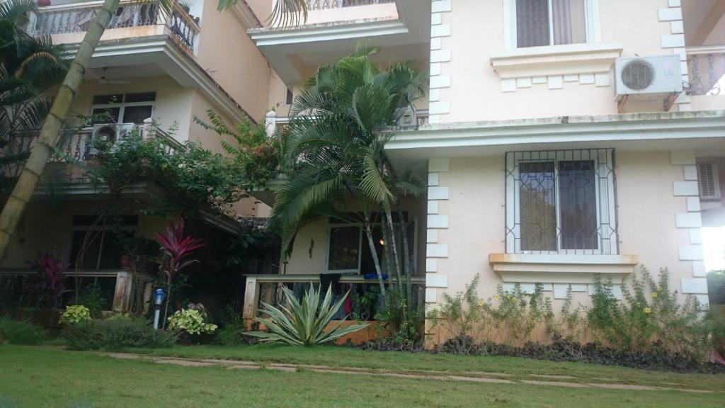a white house with a palm tree in front of it at Justin Apartment in Varca