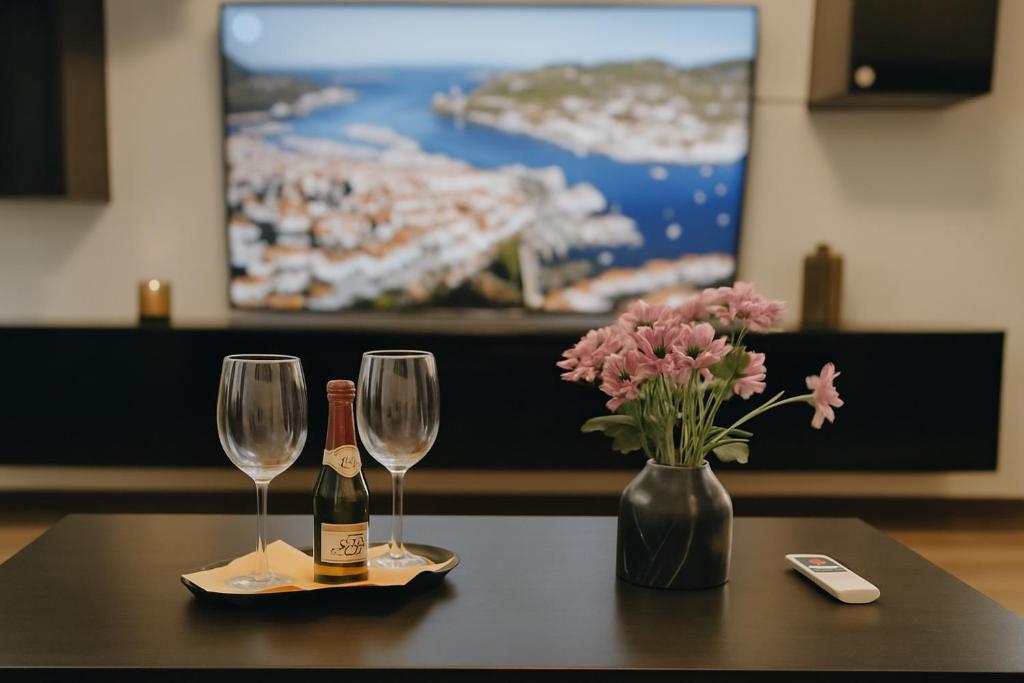 a table with two wine glasses and a vase with flowers at Unterkunft in Altstadt in Schongau