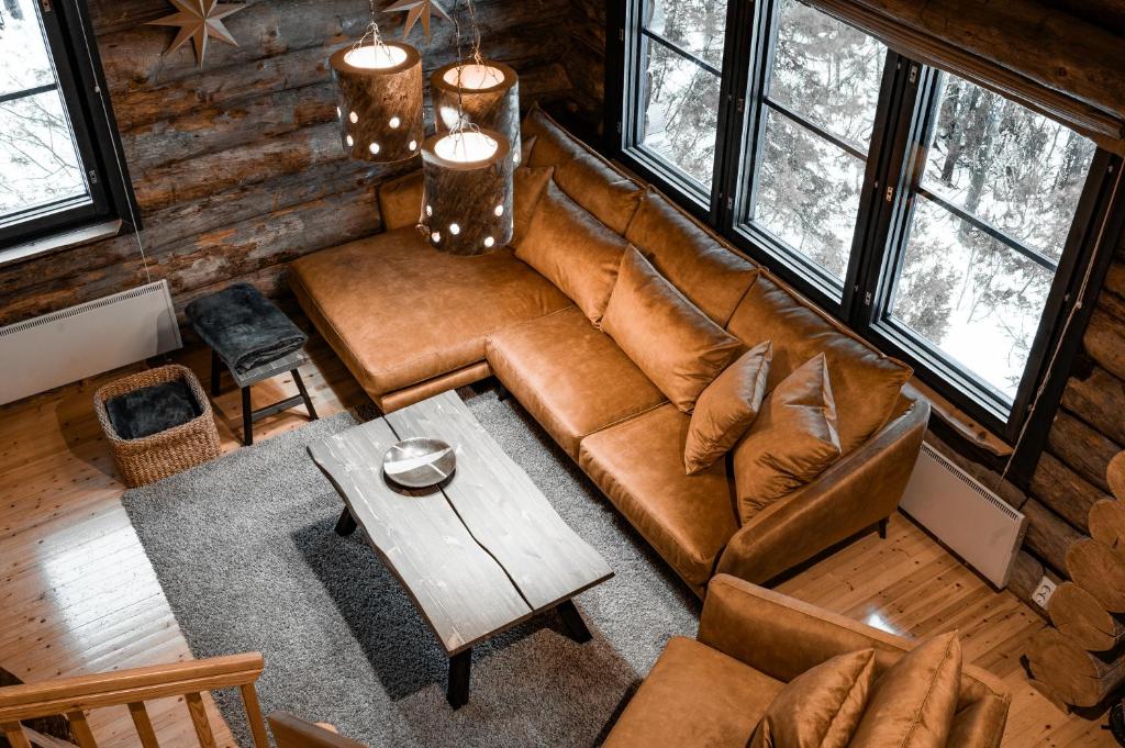 un soggiorno con un divano marrone e un tavolo di Villa Kuurupiilo a Kuusamo