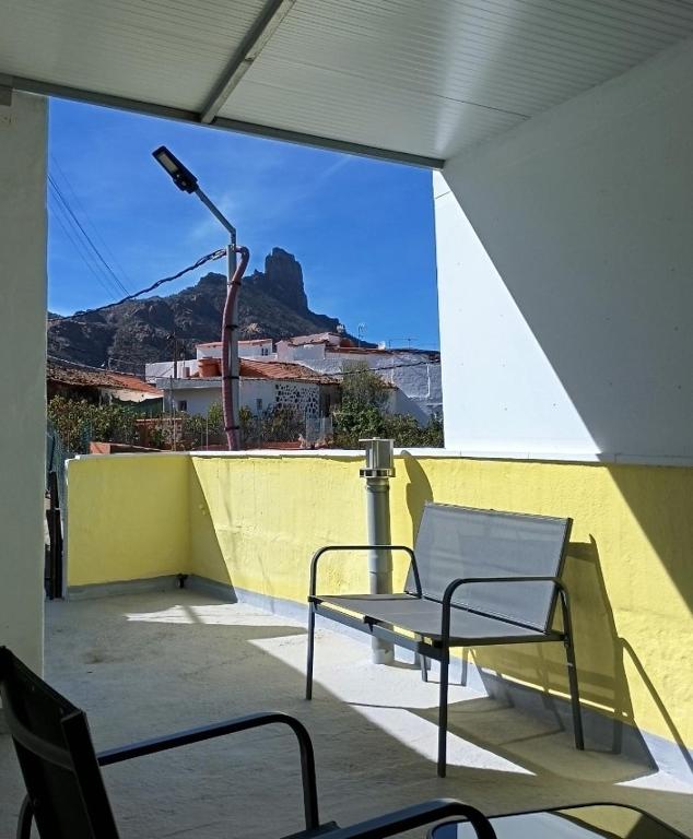 a bench on a balcony with a view of a mountain at Princess Antonella in Tejeda