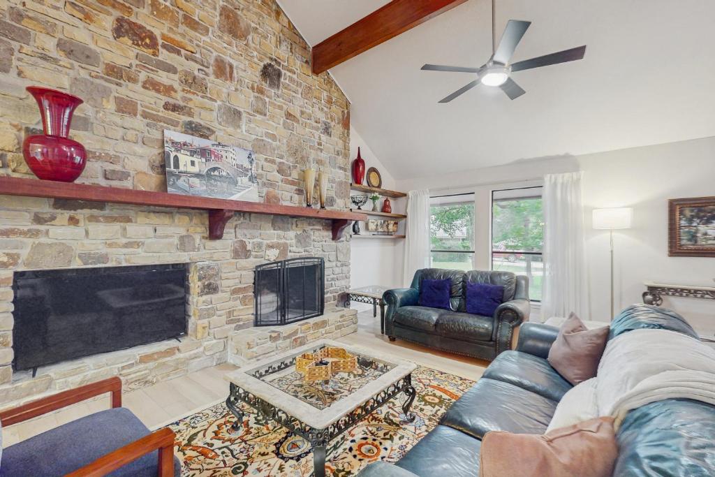 a living room with a stone fireplace and a couch at Horseshoe Bay Getaway in Horseshoe Bay