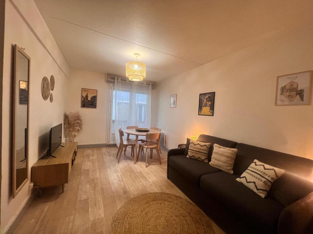 a living room with a couch and a table at La Pause Tulliste in Tulle