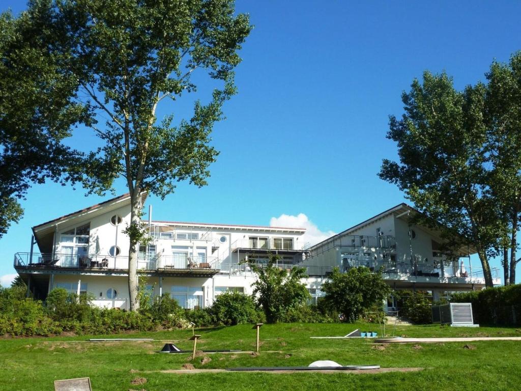 een wit gebouw met bomen ervoor bij Apartment für den perfekten Urlaub in Granzow