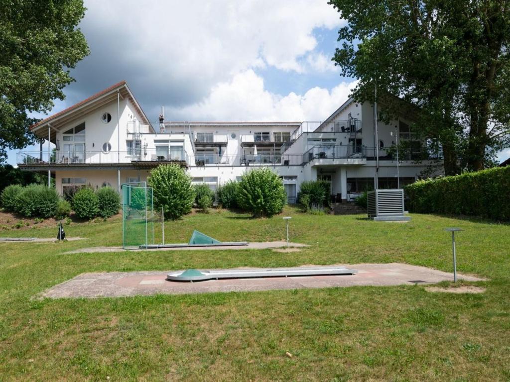 een groot wit gebouw met een honkbalveld met vangnetten bij Elegant eingerichtete Ferienwohnung in Granzow