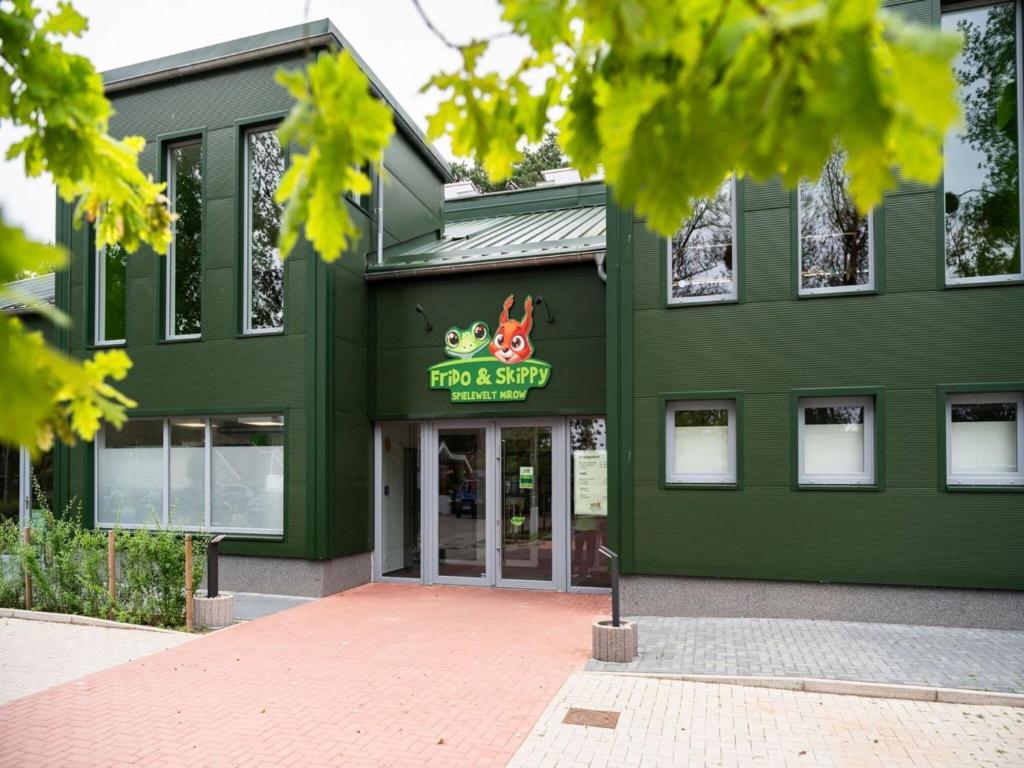 een groen gebouw met een kikkerspion-bord erop bij Appartement mit skandinavischem Flair in Granzow