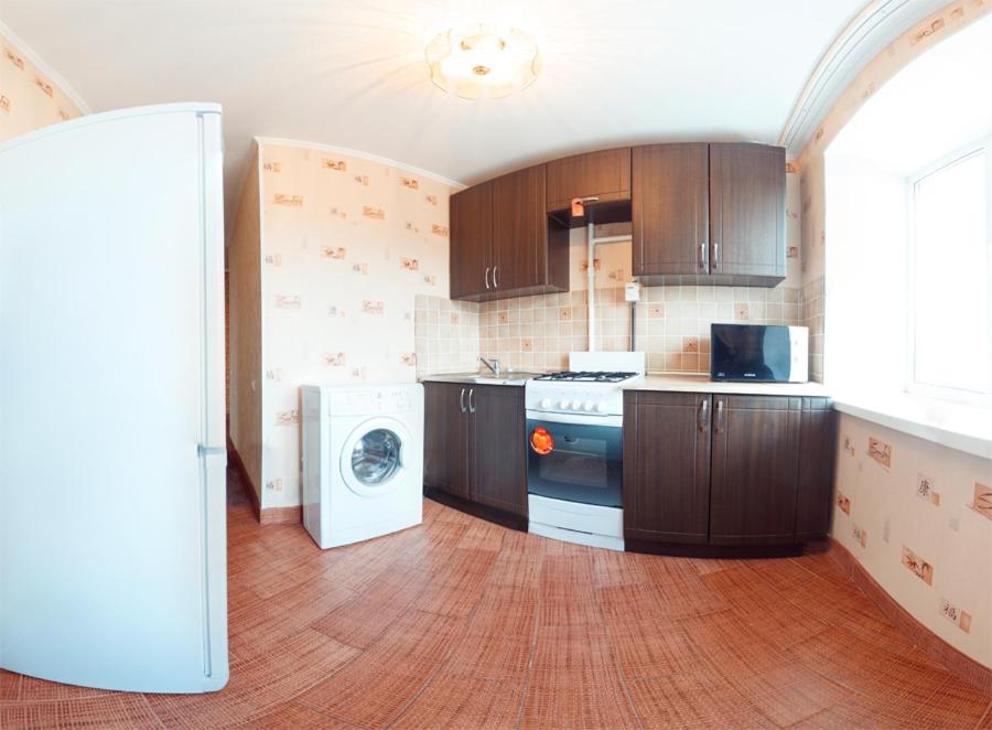 オムスクにあるOmsk Sutki Apartments on Irtyshskaya Naberezhnaya 26のキッチン(木製キャビネット、洗濯機、乾燥機付)