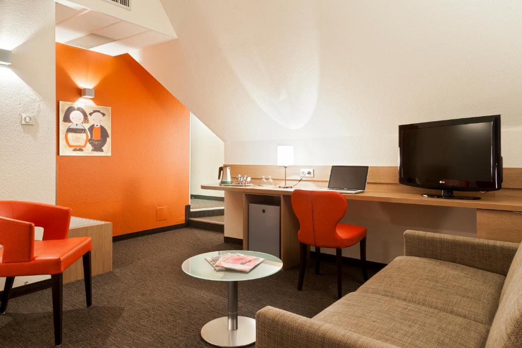 TV a/nebo společenská místnost v ubytování Kyriad Hotel Strasbourg Lingolsheim