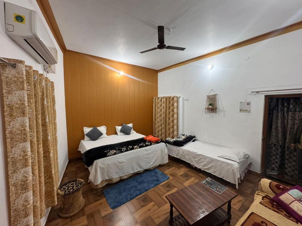um quarto com duas camas e uma mesa em AP Homestay em Faizābād